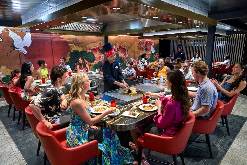 Guests enjoying cruise line specialty restaurant Izumi Hibachi with chef on Utopia of the Seas