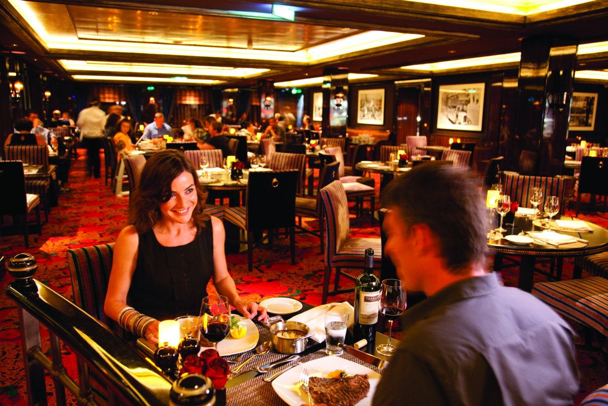 Couple dining at Cagney's Steakhouse cruise line specialty restaurant on Norwegian Cruise Line