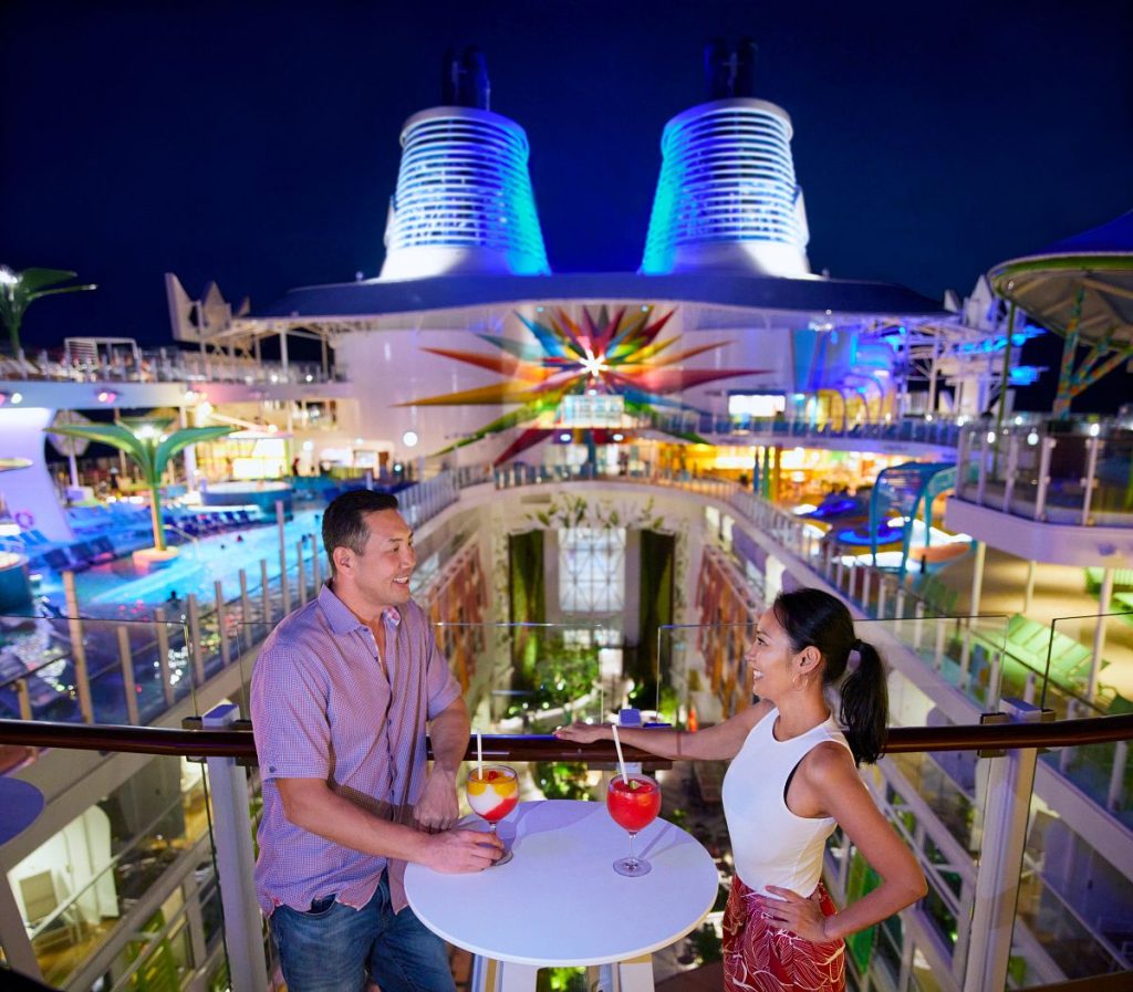 Couple enjoying frozen cocktails at night, one of the standout Icon of the Seas bars with views over the ship