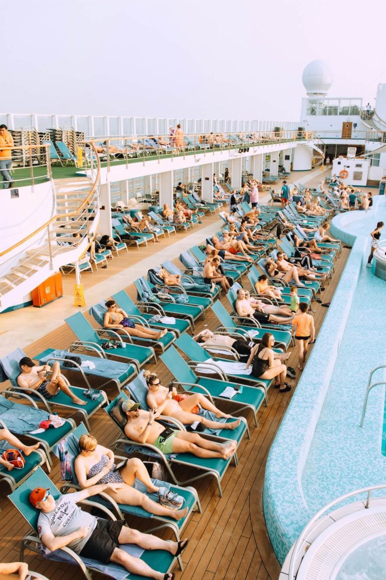 Lounge chairs with towels and personal belongings left unattended on a cruise ship pool deck