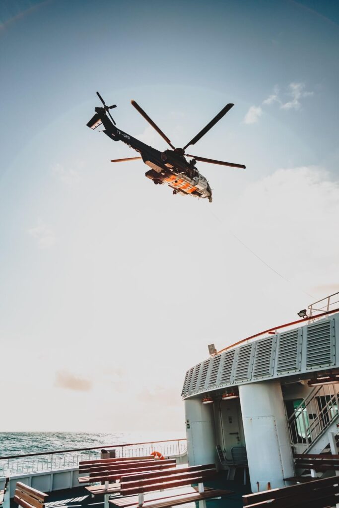 Coast Guard-style helicopter conducting a medical evacuation from a cruise ship at sea