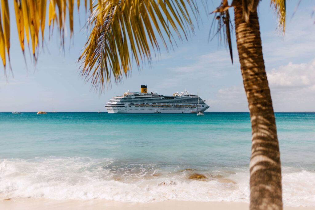 Cruise ship security in port — ship anchored offshore near a Caribbean beach