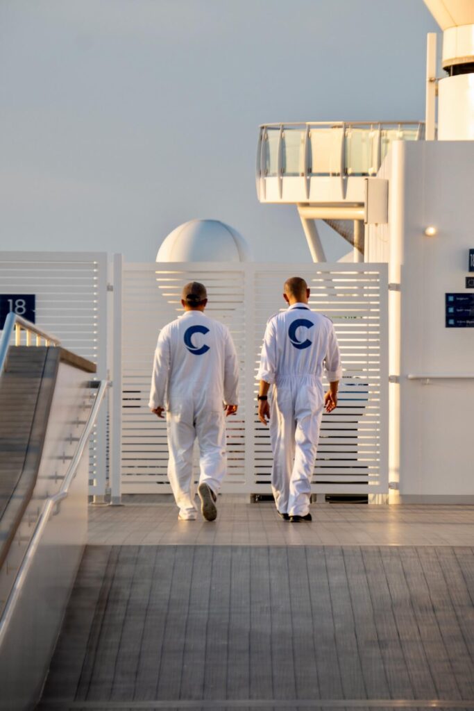 Cruise ship crew members walking the deck during daily sanitation rounds