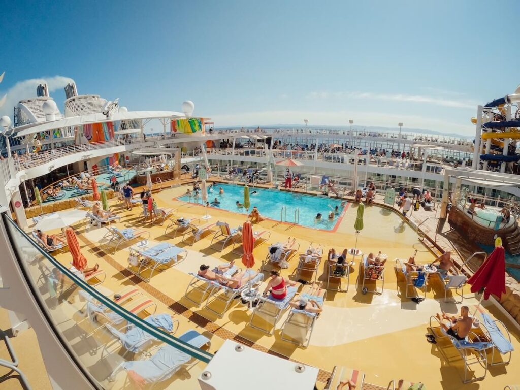 Cruise passengers relaxing poolside on a cruise ship deck