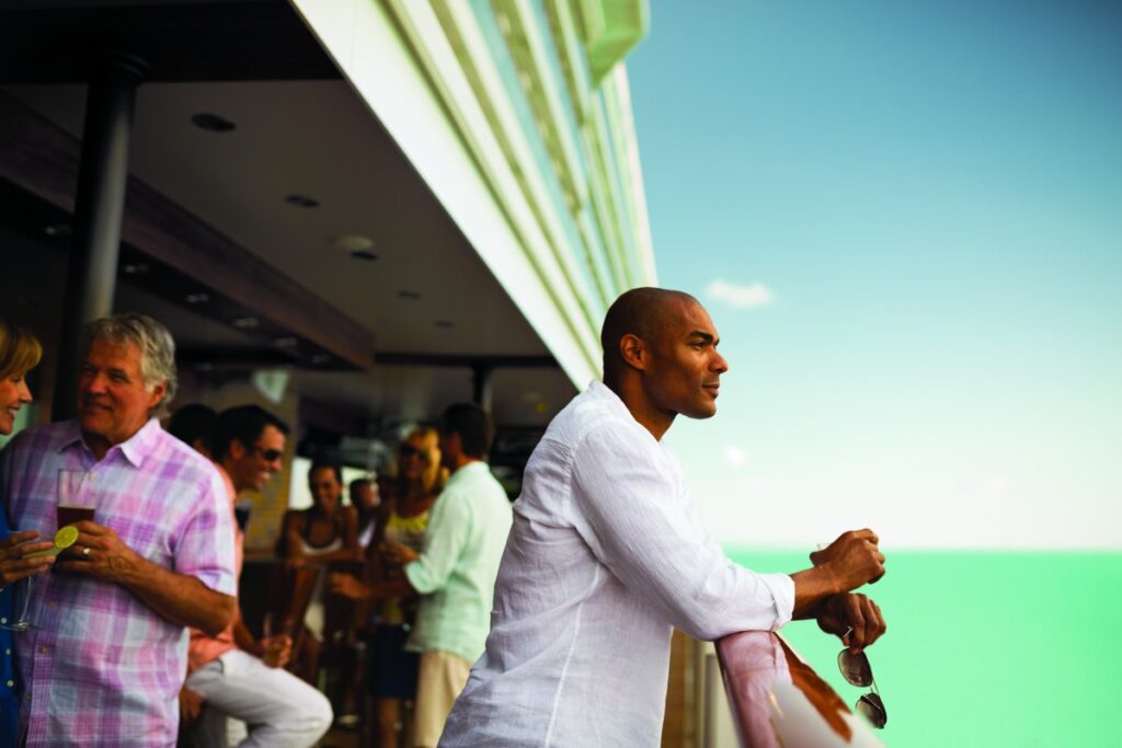 Solo traveler enjoying an open ocean view from a private cruise ship balcony