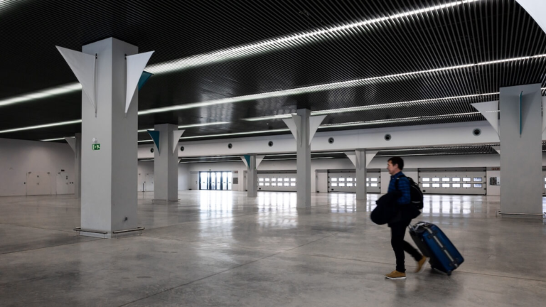 Traveler walking through a modern terminal hall, documents needed for a cruise