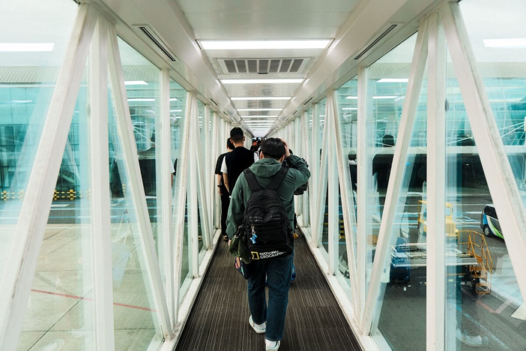 Travelers walking through a modern airport jet bridge