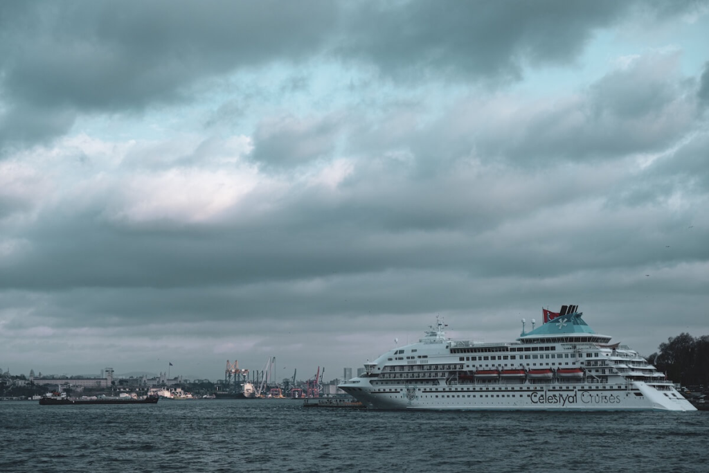 Cruise ship docked at port under a dramatic cloudy sky