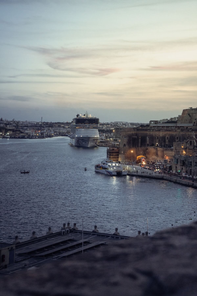 Cruise ship entering Valletta harbor at twilight