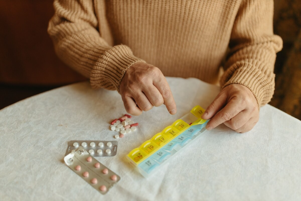 Traveler organizing medications into a weekly pill organizer